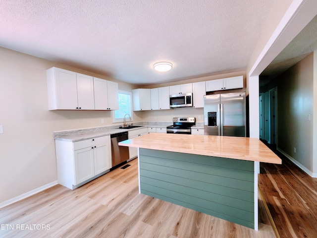 kitchen featuring sink, stainless steel appliances, and white cabinets