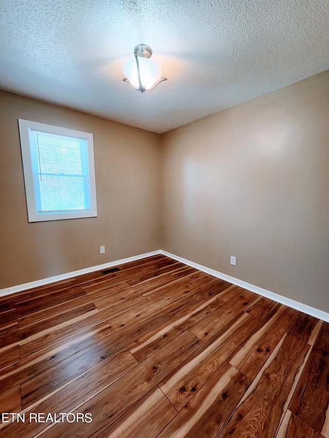 empty room featuring hardwood / wood-style floors and a textured ceiling