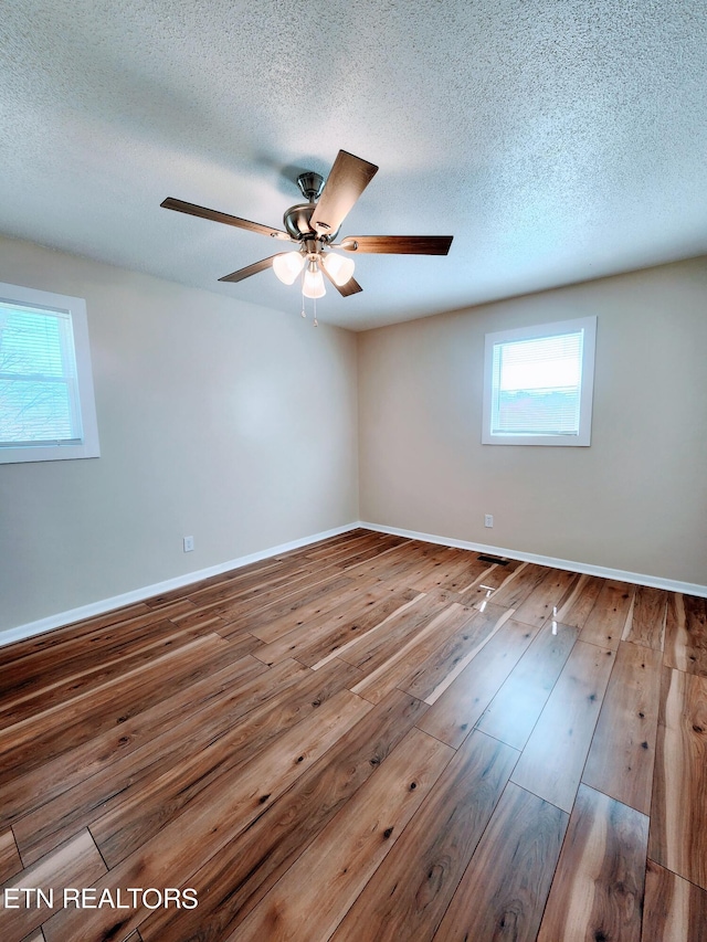 spare room featuring ceiling fan, hardwood / wood-style flooring, and a textured ceiling