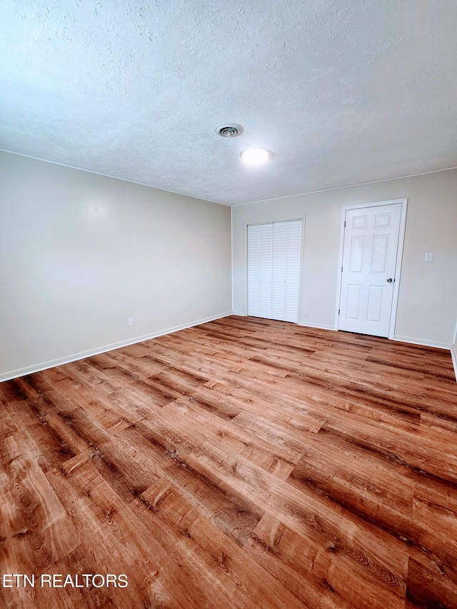 spare room with wood-type flooring and a textured ceiling