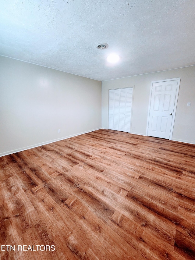 unfurnished bedroom with wood-type flooring and a textured ceiling