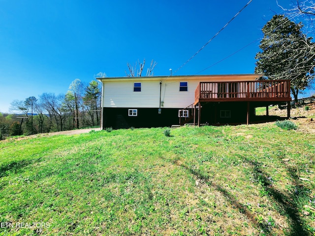 rear view of property with a lawn and a wooden deck