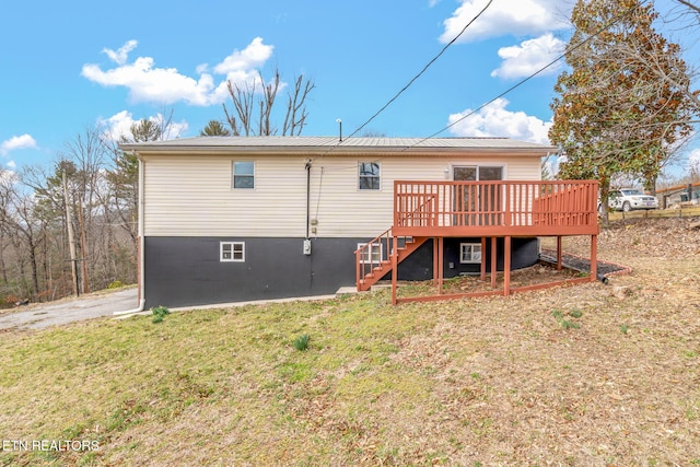 rear view of house featuring stairs, a lawn, and a wooden deck