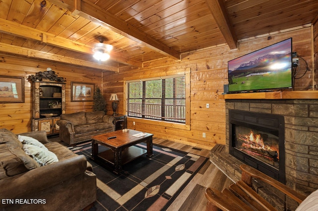 living room with wooden walls, beamed ceiling, hardwood / wood-style floors, wooden ceiling, and a fireplace