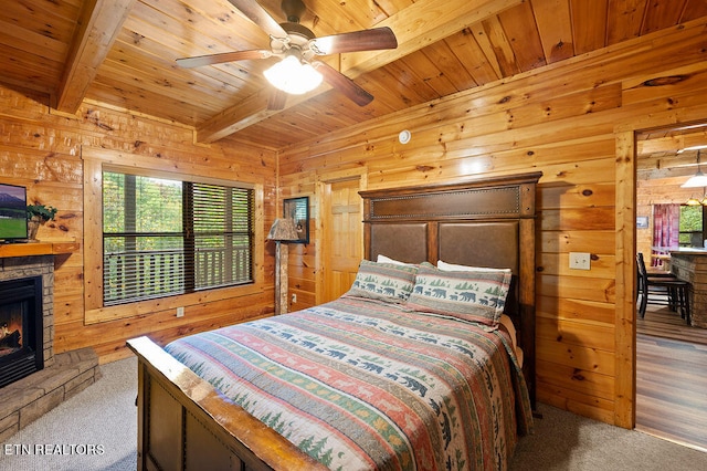 carpeted bedroom featuring a fireplace, beam ceiling, and wood walls