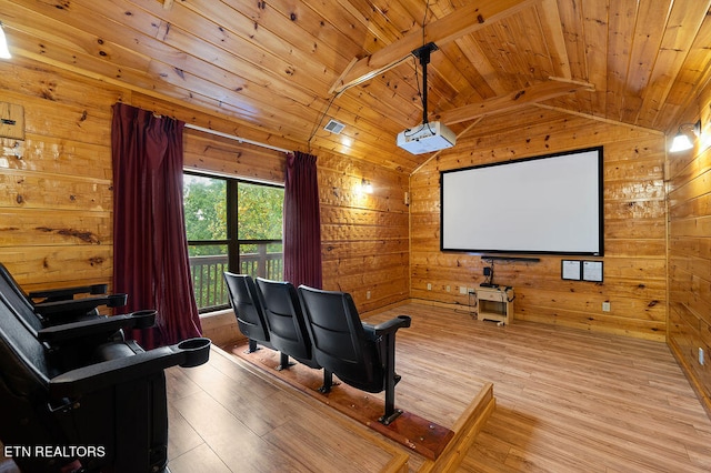 cinema room with light wood-type flooring, vaulted ceiling with beams, wood walls, and wood ceiling