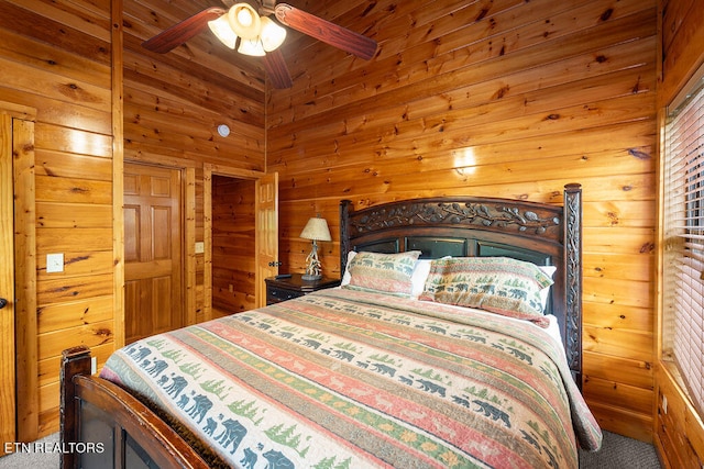 bedroom with carpet, wooden walls, and ceiling fan