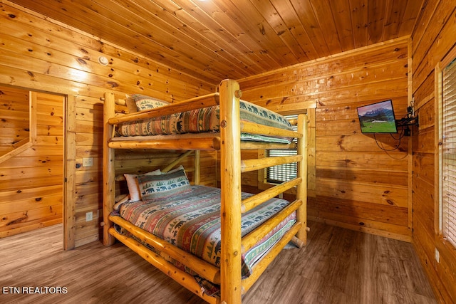 bedroom with wood-type flooring, wood ceiling, and wood walls