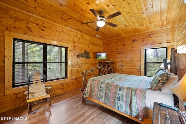 bedroom featuring wooden walls, ceiling fan, wooden ceiling, and wood-type flooring