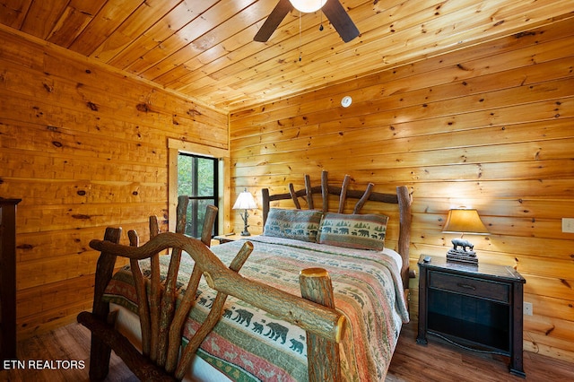 bedroom with ceiling fan, wood ceiling, wood walls, and hardwood / wood-style floors