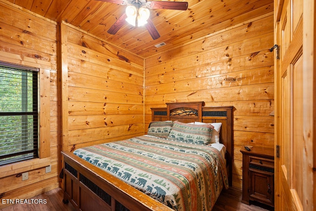 bedroom featuring ceiling fan, wood ceiling, wood walls, and dark hardwood / wood-style flooring