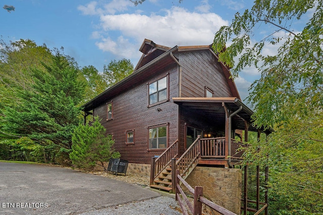 view of side of home with a porch and central air condition unit