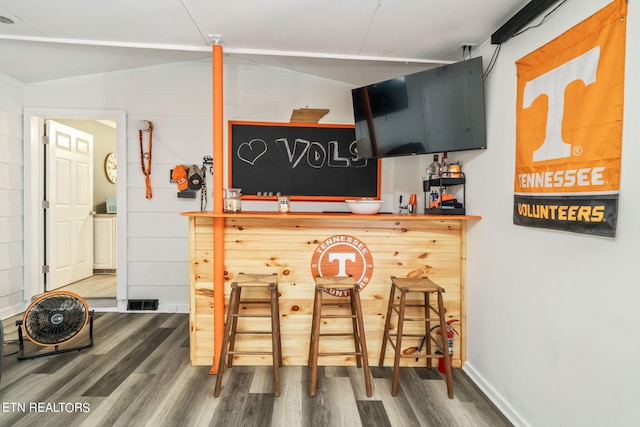 bar with hardwood / wood-style floors and vaulted ceiling