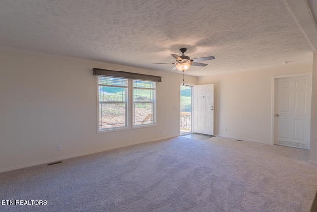 empty room with ceiling fan, a textured ceiling, and carpet