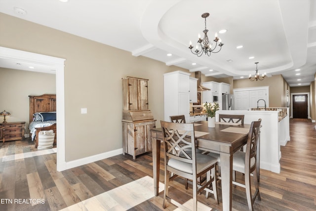 dining area featuring dark hardwood / wood-style floors, an inviting chandelier, and sink