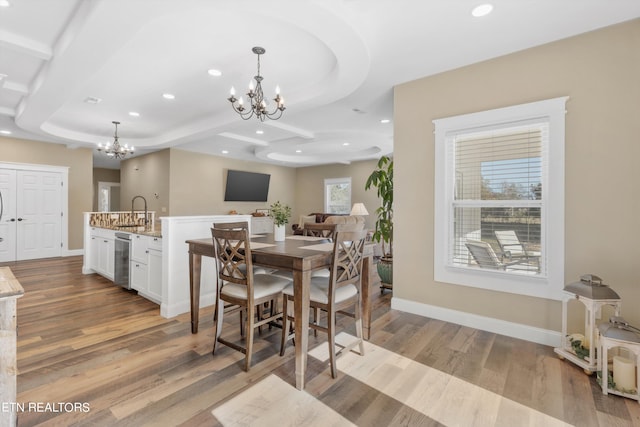 dining space featuring an inviting chandelier, light wood-type flooring, and plenty of natural light