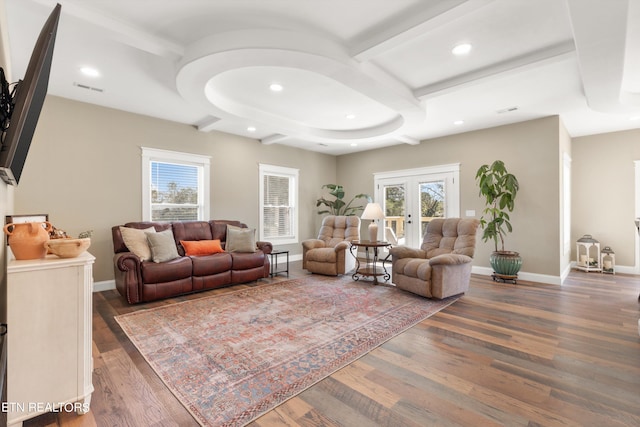 living room featuring a healthy amount of sunlight, beam ceiling, dark wood-type flooring, and french doors