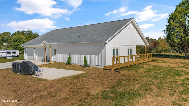 rear view of house with a wooden deck, a yard, and a patio