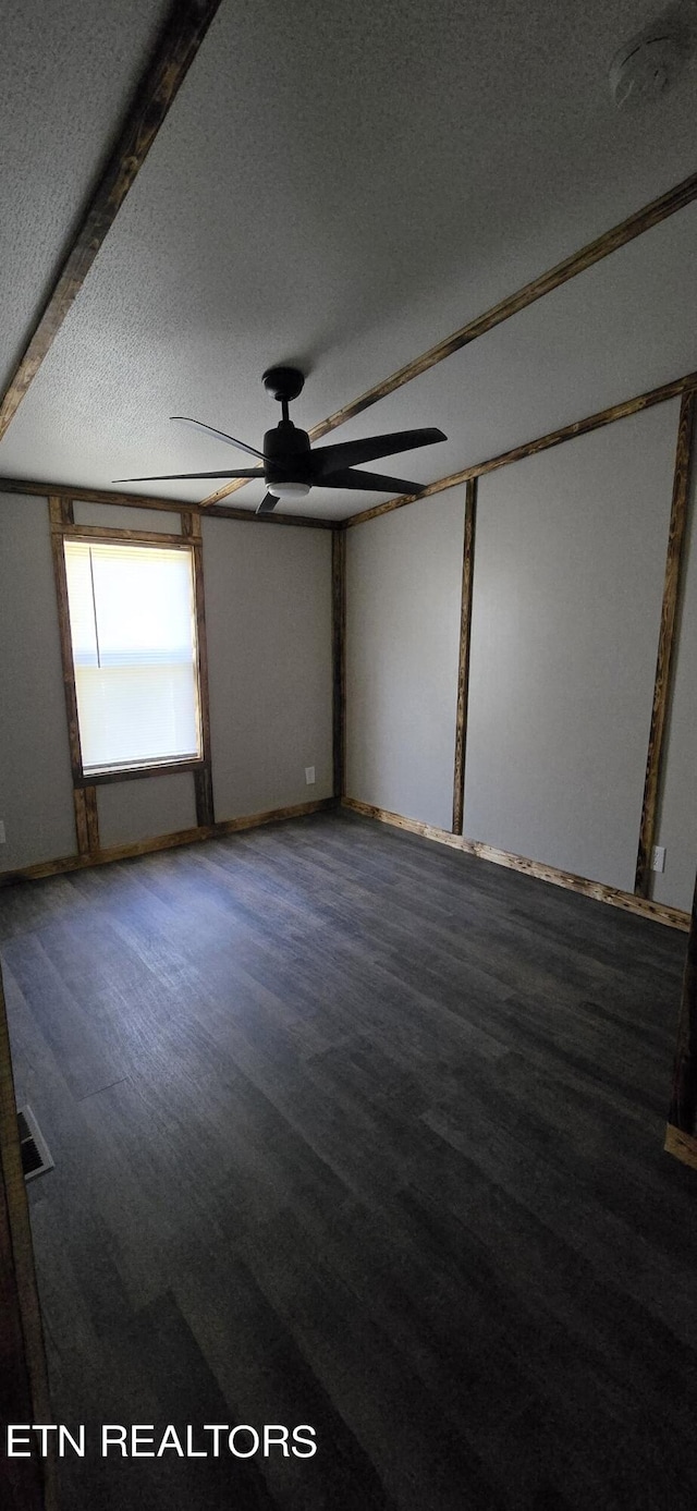 spare room with beamed ceiling, hardwood / wood-style floors, a textured ceiling, and ceiling fan