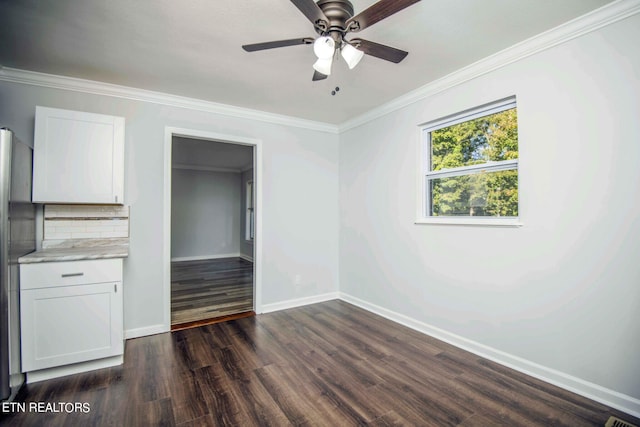 interior space with stainless steel refrigerator, ceiling fan, dark wood-type flooring, and ornamental molding