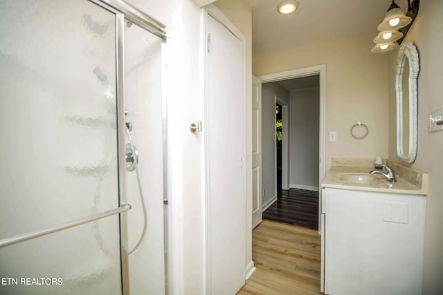 bathroom featuring wood-type flooring, vanity, and walk in shower