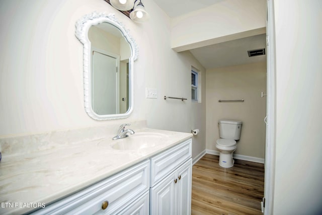 bathroom featuring vanity, hardwood / wood-style flooring, and toilet