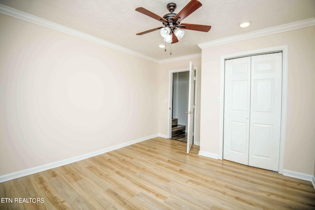 unfurnished bedroom with ceiling fan, light hardwood / wood-style flooring, crown molding, a textured ceiling, and a closet