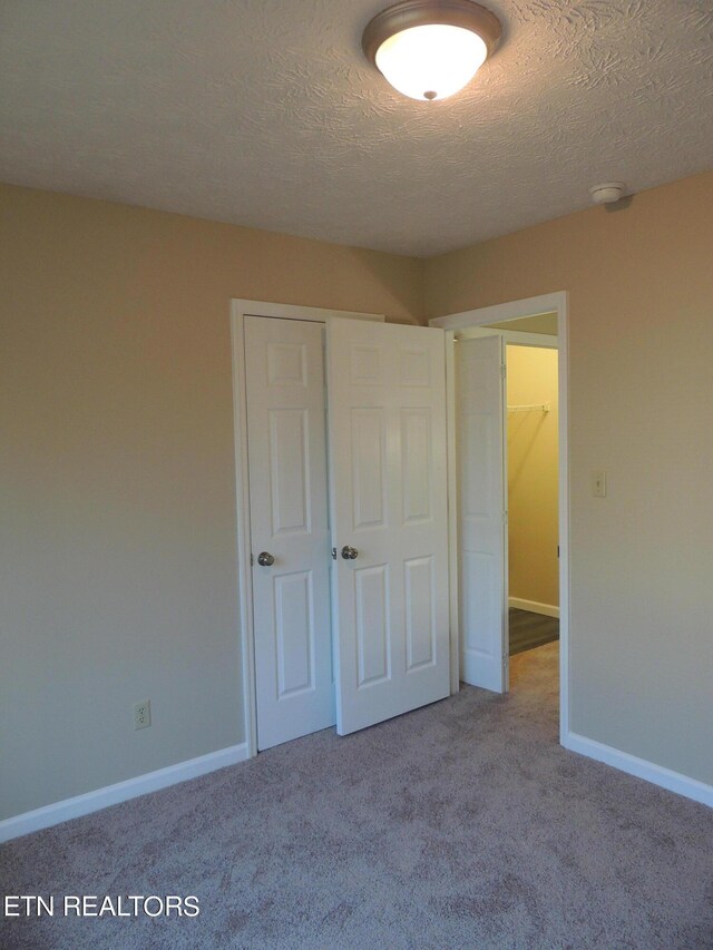 1432 Pheasants Glen Dr, Knoxville, TN 37923 - unfurnished bedroom featuring a textured ceiling, baseboards, a closet, and carpet floors