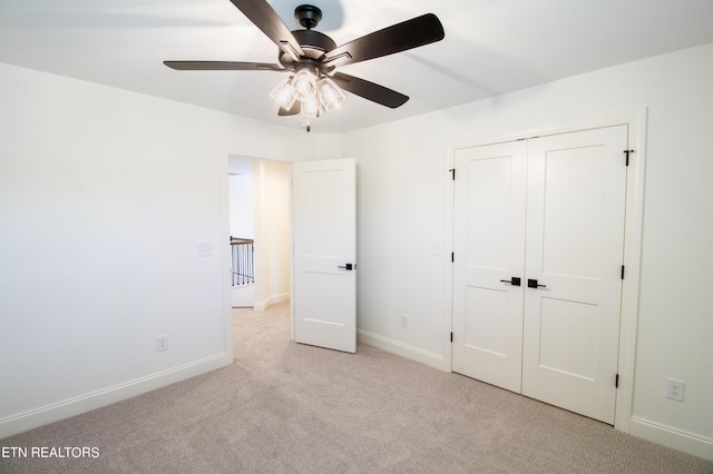 unfurnished bedroom with carpet floors, baseboards, a closet, and ceiling fan