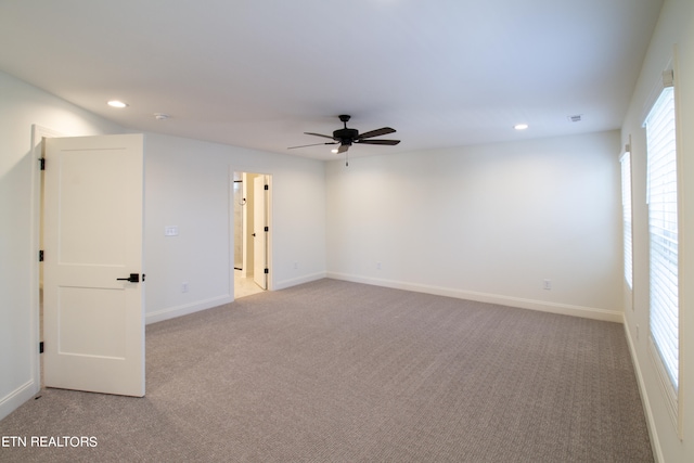 carpeted spare room with ceiling fan