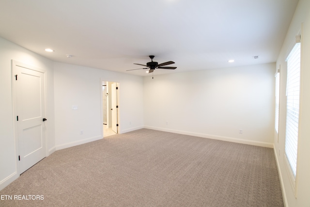 unfurnished room with ceiling fan and light carpet