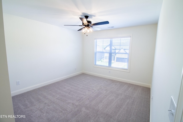 carpeted spare room with ceiling fan