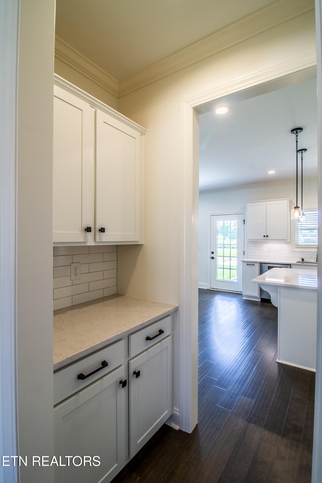 kitchen with light stone counters, dark hardwood / wood-style floors, backsplash, white cabinets, and pendant lighting