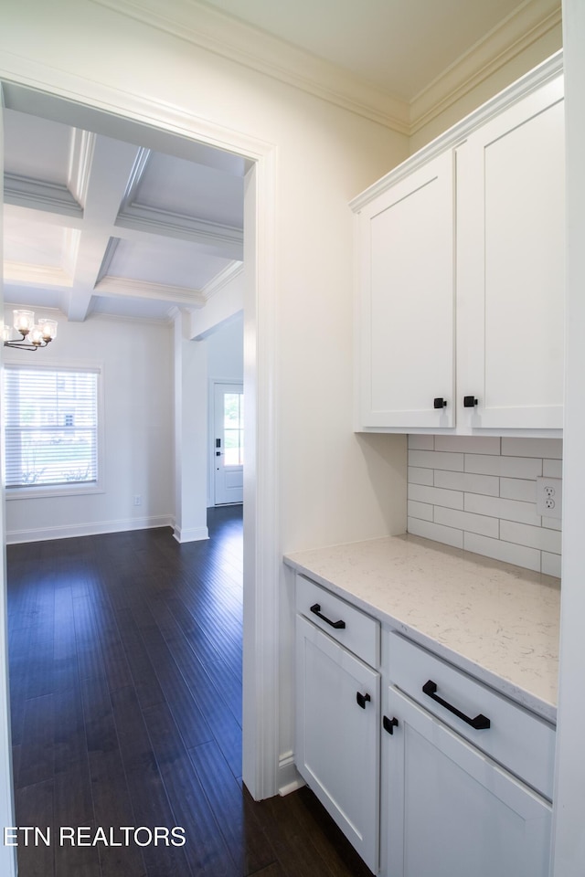 hallway with crown molding, beamed ceiling, a notable chandelier, and dark wood-style floors