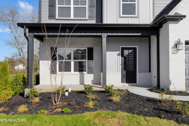 view of exterior entry featuring covered porch