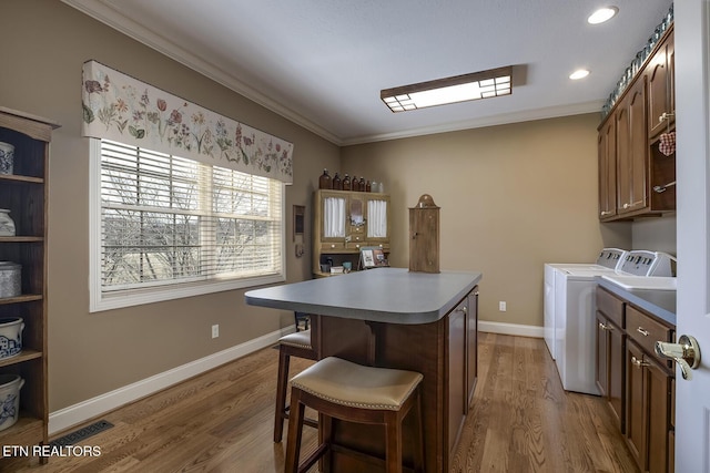 washroom with wood finished floors, cabinet space, and ornamental molding