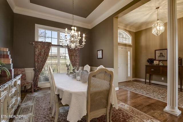 dining space with wainscoting, wood finished floors, a chandelier, and crown molding