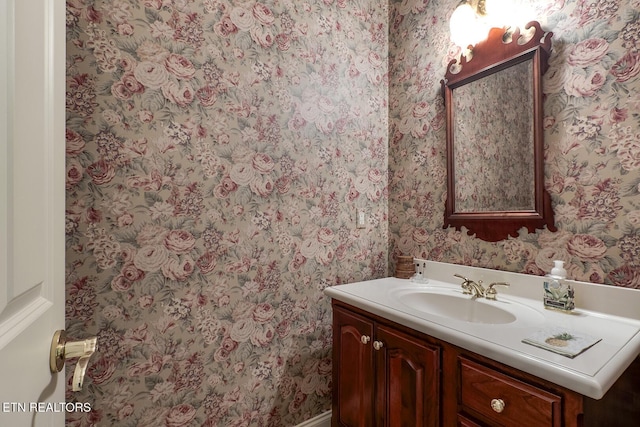 bathroom with wallpapered walls and vanity