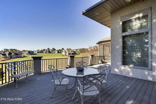 wooden terrace with outdoor dining space and a residential view