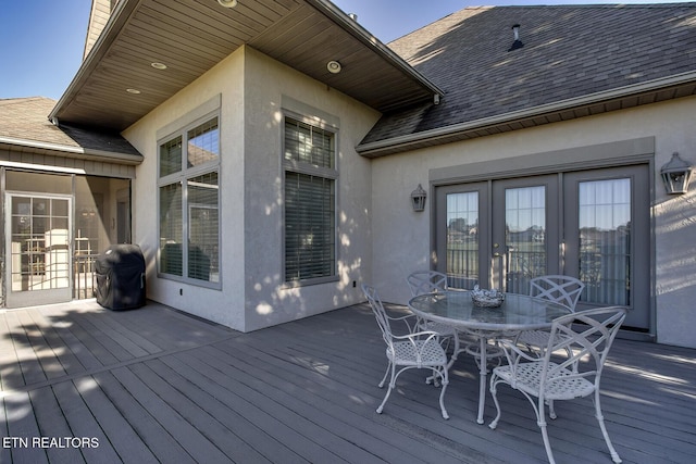 wooden terrace with grilling area, french doors, and outdoor dining area