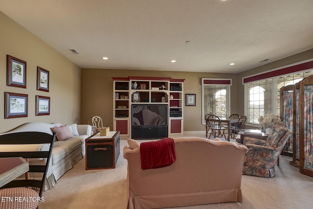 living room with visible vents, recessed lighting, a textured ceiling, and carpet