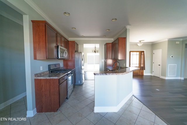 kitchen with light hardwood / wood-style floors, dark stone counters, crown molding, kitchen peninsula, and appliances with stainless steel finishes