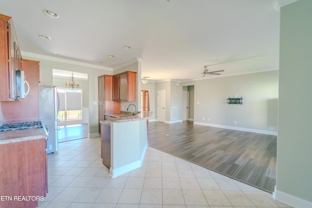 kitchen featuring light hardwood / wood-style floors, ceiling fan with notable chandelier, fridge, crown molding, and kitchen peninsula