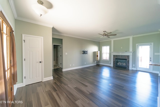 unfurnished living room with crown molding, ceiling fan, dark wood-type flooring, and a tiled fireplace