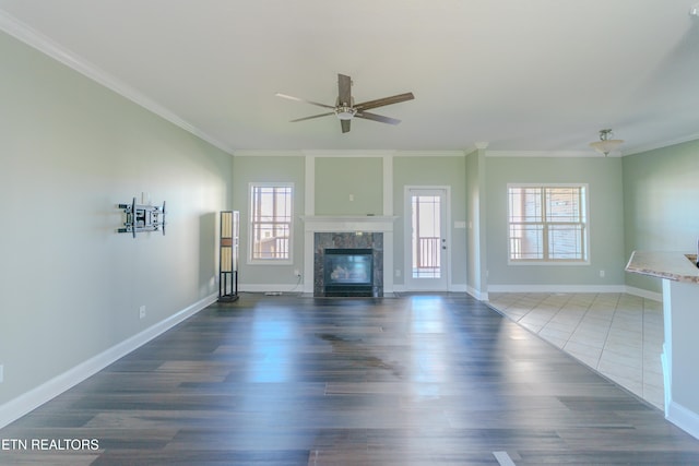 unfurnished living room with ornamental molding, dark wood-type flooring, and a healthy amount of sunlight