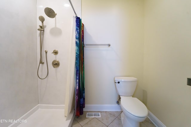 bathroom featuring a shower with curtain, toilet, and tile patterned floors