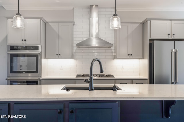 kitchen featuring appliances with stainless steel finishes, pendant lighting, light stone countertops, and wall chimney range hood