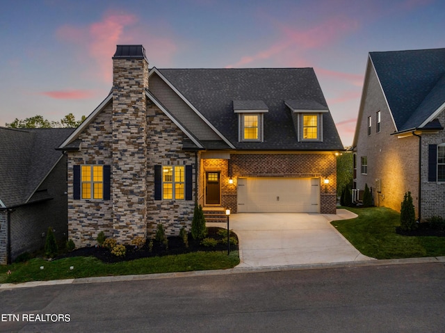 craftsman-style home with a chimney, central AC unit, an attached garage, driveway, and brick siding