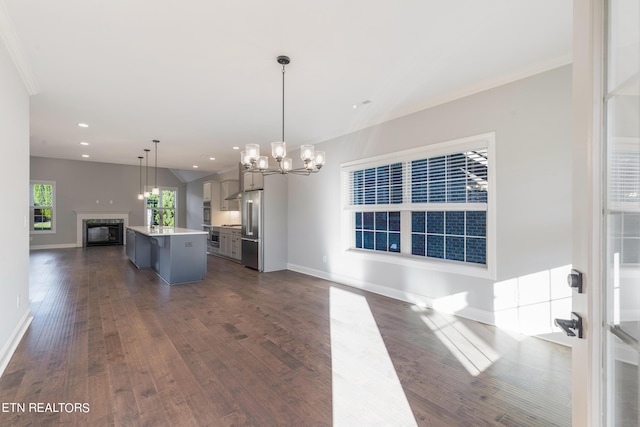 kitchen featuring open floor plan, dark wood-type flooring, baseboards, and a notable chandelier