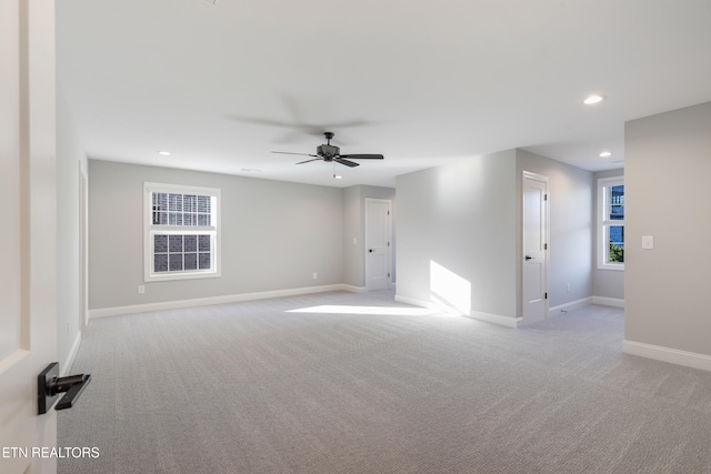 empty room featuring ceiling fan and light colored carpet